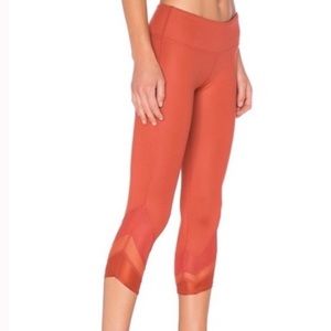 alo orange cropped leggings with mesh cutout